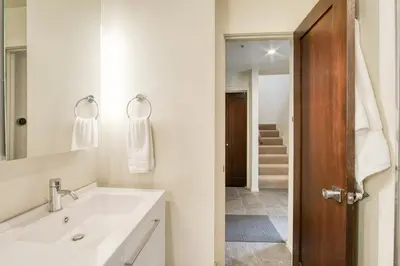 a white bathroom with a sink and a mirror at Valley View Townhome # 10 at Palisades by Tahoe Getaways - Shuttle & Walk to the Village! in Olympic Valley