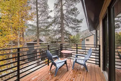 two chairs and a table on a deck with trees at Valley View Townhome # 10 at Palisades by Tahoe Getaways - Shuttle & Walk to the Village! in Olympic Valley
