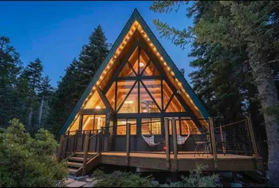 a large glass house with a roof at Mountain Modern The Tahoe A-Frame w Private Pier in Homewood