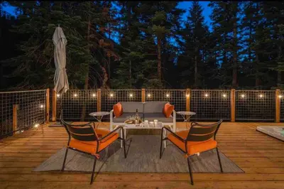 a patio with a table and chairs on a deck at Mountain Modern The Tahoe A-Frame w Private Pier in Homewood