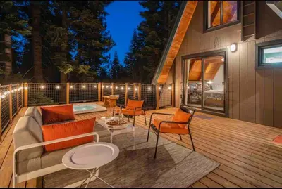 a patio with a couch and chairs on a deck at Mountain Modern The Tahoe A-Frame w Private Pier in Homewood