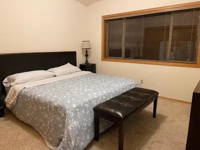 a bedroom with a bed and a chair and a window at 6000 sqft Pine House with indoor swimming pool in Reno