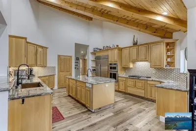 a large kitchen with wooden cabinets and wooden floors at 6000 sqft Pine House with indoor swimming pool in Reno