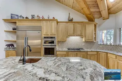 a kitchen with wooden cabinets and a marble counter top at 6000 sqft Pine House with indoor swimming pool in Reno