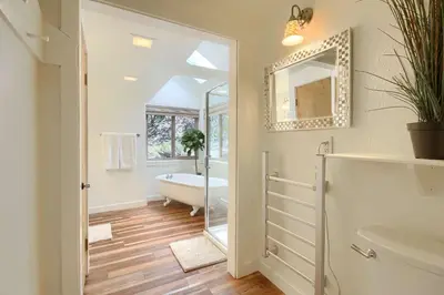 a bathroom with a tub and a sink and a mirror at Tranquility House-Riverfront-Fireplace-Sleeps six in Oakhurst