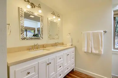 a bathroom with a sink and a large mirror at Tranquility House-Riverfront-Fireplace-Sleeps six in Oakhurst