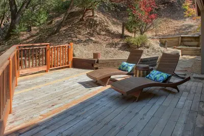 two chairs and a table on a wooden deck at Tranquility House-Riverfront-Fireplace-Sleeps six in Oakhurst