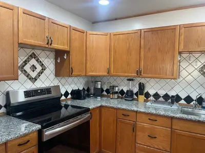 a kitchen with wooden cabinets and a stove top oven at A Little Bit Of Country in Visalia
