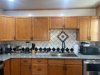 a kitchen with wooden cabinets and a sink at A Little Bit Of Country in Visalia
