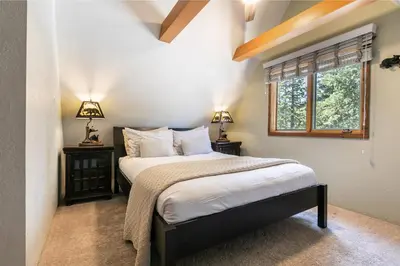 a bedroom with a bed with two night stands and two lamps at Tahoe Dreamer by Tahoe Getaways - Pet Friendly 4 BR Gated Home w Fenced Yard, Game Room & Walk to Lake! in Carnelian Bay