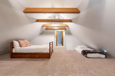 a attic room with two beds and a ceiling at Tahoe Dreamer by Tahoe Getaways - Pet Friendly 4 BR Gated Home w Fenced Yard, Game Room & Walk to Lake! in Carnelian Bay