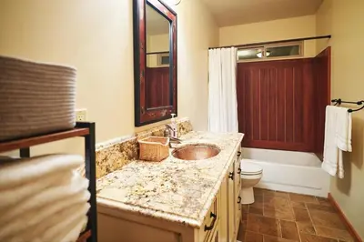 a bathroom with a sink and a toilet and a mirror at Rare Deluxe Family Cabin - Yosemite & Bass Lake in Bass Lake Annex
