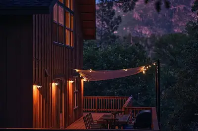 a deck with a string of lights on a house at Rare Deluxe Family Cabin - Yosemite & Bass Lake in Bass Lake Annex