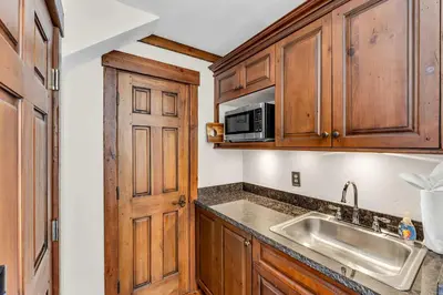 a kitchen with wooden cabinets and a sink and a microwave at 3-Level Incline Village Retreat with Fireplace in Incline Village