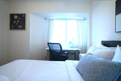 a bedroom with a bed and a desk and a window at Stunning Waterfront 3BR Retreat - Perfect Getaway in Discovery Bay