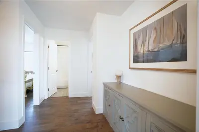 a hallway with white walls and a painting on the wall at Stunning Waterfront 3BR Retreat - Perfect Getaway in Discovery Bay