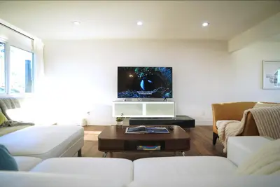 a living room with a couch and a tv on a wall at Stunning Waterfront 3BR Retreat - Perfect Getaway in Discovery Bay