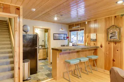 a kitchen with a bar with stools and a refrigerator at 5 Mi to Dodge Ridge Cabin in Strawberry in Strawberry