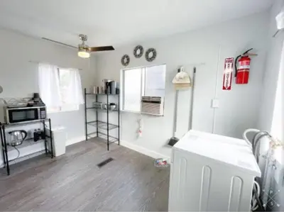 a white room with a kitchen with a stove at Nifty Trailer With Spacious Parking in Visalia