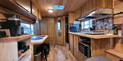 a kitchen with wooden walls and wooden flooring at Cozy Farm Stay for Two in Three Rivers