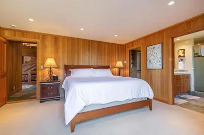 a bedroom with a large bed and wooden walls at Clouds Rest in Dollar Point By Tahoe Getaways - Lake views - Hot Tub & Game Room in Tahoe City