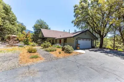 a house with a garage and a driveway at Cody's Comfy Cabin- Near Yosemite in Mariposa