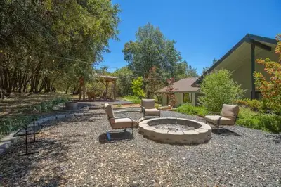a patio with chairs and a fire pit in a yard at Cody's Comfy Cabin- Near Yosemite in Mariposa
