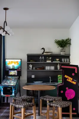 a room with a table and a video game at Luxury Lakefront 5 Br Home Hot Tub Arcade in Truckee