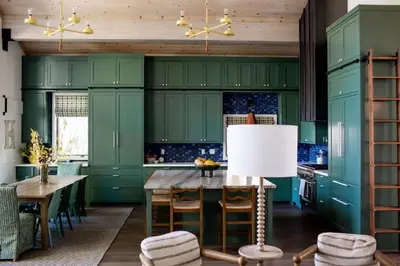 a kitchen with green cabinets and a table with chairs at Luxury Lakefront 5 Br Home Hot Tub Arcade in Truckee