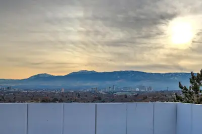a fence with a city and mountains in the background at Spacious Cozy and Furnished Bedroom Private Bathroom, Close to Everything in Reno