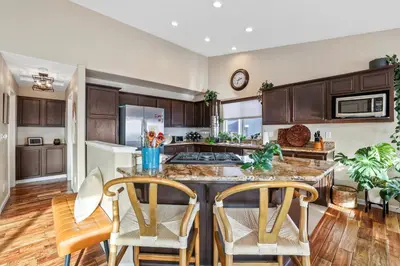 a kitchen with wooden cabinets and a table with chairs at Spacious Cozy and Furnished Bedroom Private Bathroom, Close to Everything in Reno