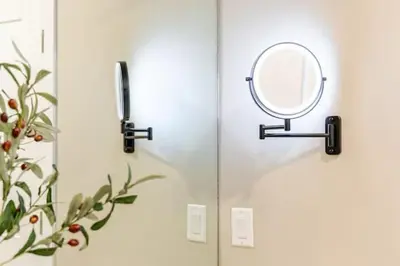 a mirror on a wall in a bathroom at Amazing Water View with Jacuzzi & Sky Lounge in Sparks
