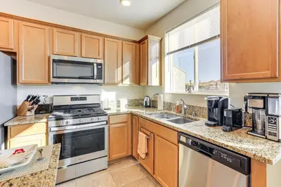 a kitchen with wooden cabinets and a stove top oven at 4 Mi to Dtwn Family-Friendly Townhome in Reno in Reno