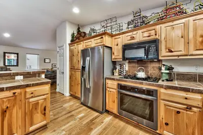 a kitchen with wooden cabinets and stainless steel appliances at Kamp Koyukon 1939K in South Lake Tahoe