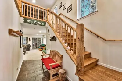a staircase in a home with a red chair at Kamp Koyukon 1939K in South Lake Tahoe