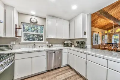 a kitchen with white cabinets and a wooden ceiling at 1540TS Snowy Owl Cabin in South Lake Tahoe