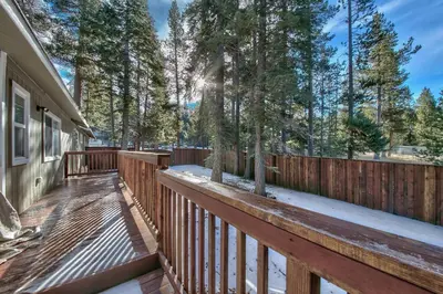 a wooden deck with a fence and trees at 1540TS Snowy Owl Cabin in South Lake Tahoe
