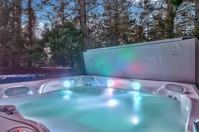 a jacuzzi tub with a large screen in a backyard at 1540TS Snowy Owl Cabin in South Lake Tahoe