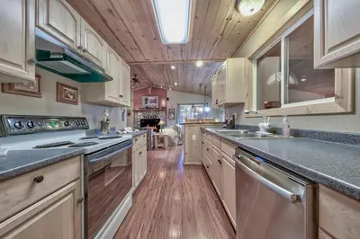 a large kitchen with wooden floors and white cabinets at 1965NP The Bears Den in South Lake Tahoe