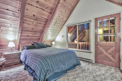a bedroom with a bed and a wooden wall at Cholula Chalet 811C in South Lake Tahoe