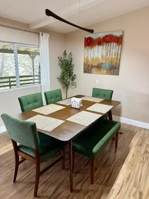 a dining room with a wooden table and green chairs at Scenic Lake House & Dog Friendly in Wofford Heights
