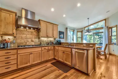 a kitchen with wooden cabinets and wooden floors at Das Waldhaus 1973P in South Lake Tahoe