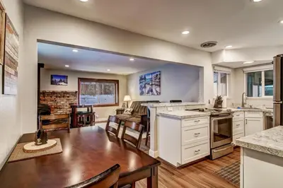 a kitchen with white cabinets and a wooden table at 2574C Bear Creek Cabin in South Lake Tahoe