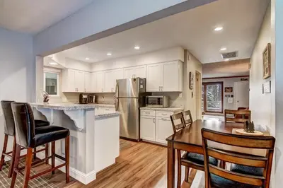 a kitchen with white cabinets and a table and chairs at 2574C Bear Creek Cabin in South Lake Tahoe