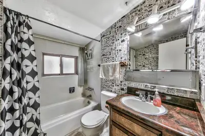 a bathroom with a sink and a toilet and a tub at 1207S Cabin in the Pines in South Lake Tahoe