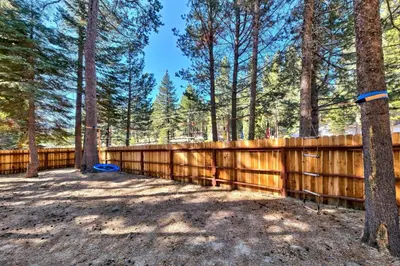 a wooden fence in a yard with trees at 1577A The Tahoe Lazy Bear in South Lake Tahoe