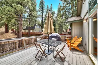 a patio with a table and chairs on a deck at 1144GB The Golden Bear Retreat in South Lake Tahoe