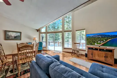 a living room with a blue couch and a table at Tall Pines in South Lake Tahoe