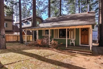 a small green house with a chair in the yard at 3993C Cedar Cabin Lake Tahoe in South Lake Tahoe
