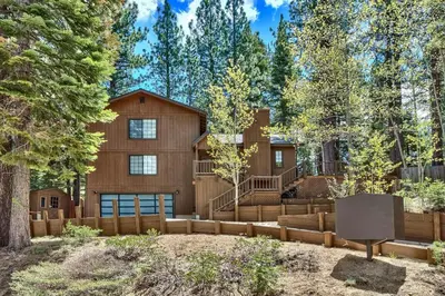 a home in the woods with a fence at 1760T Thunderbird Cabin in South Lake Tahoe